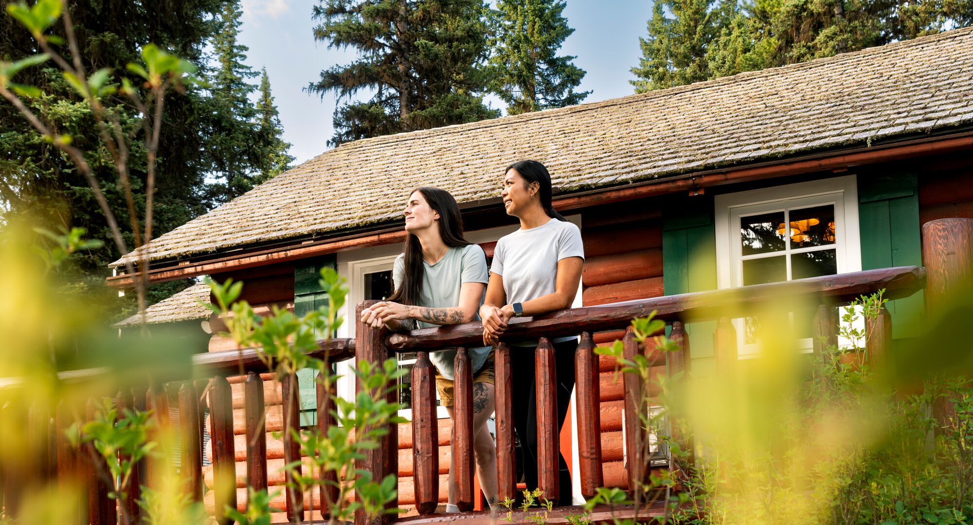 Two people looking out from the balcony of a cabin in Banff National Park